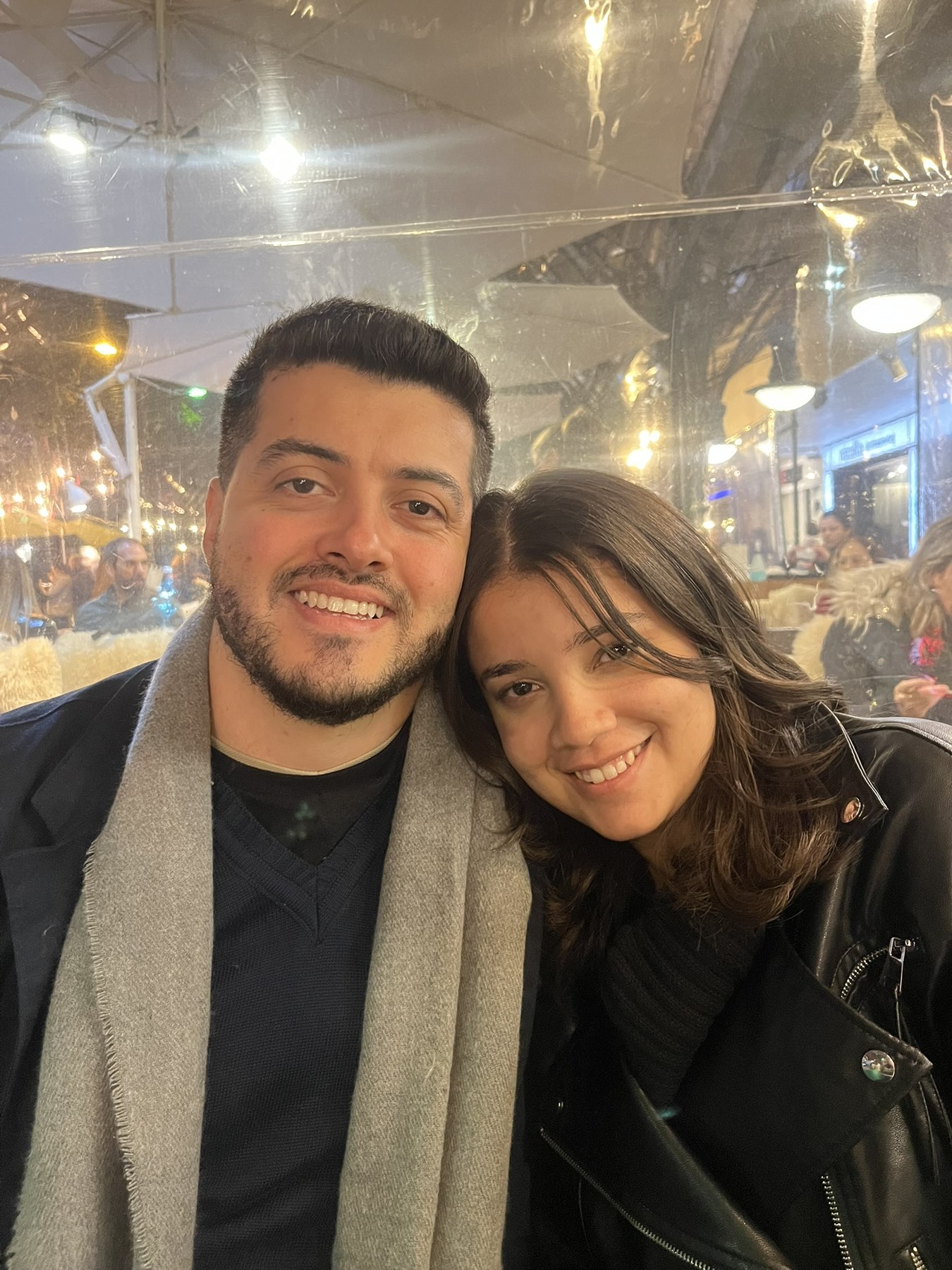 Leandro e Paolla sorrindo juntos em um jantar